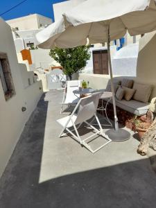 patio ze stołem i parasolem w obiekcie Cave house mARTrona w mieście Foinikiá +19 zdjęć
