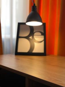 uma imagem num quadro preto sobre uma mesa com um candeeiro em GoConcept Studio em Iaşi