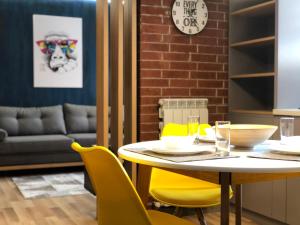 a dining room with a table and yellow chairs at GoConcept Studio in Iaşi