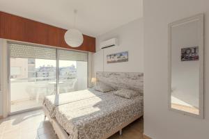 una camera da letto con un letto e una grande finestra di Furnished Seafront Studio a Larnaka