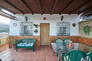 a patio with a table and chairs and a door at Casa Rural Mi Cortijo in Nerja