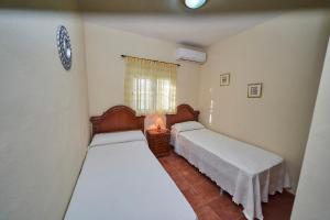 a bedroom with two beds and a table with a lamp at Casa Rural Mi Cortijo in Nerja +41 photos
