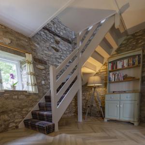een trap in een kamer met een stenen muur bij Bilsdale Cottage in Helmsley