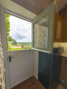 a kitchen with a large window in the door at Bilsdale Cottage in Helmsley