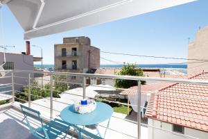 balcone con vista e tavolo e sedie blu. di Marion Apartments a Skala Kallirachis