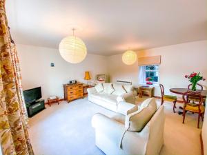 a living room with white couches and a table at Harbour View in Portree