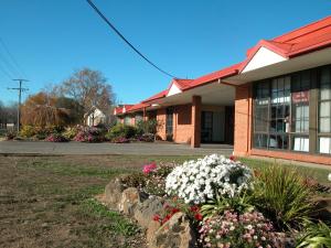 a building with a bunch of flowers in front of it at Ambassador Motor Inn in Ballarat