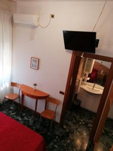 una camera con tavolo, sedie e televisore di Sacco Alloggi a Rovigo Altre 38 foto