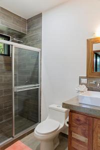 y baño con aseo, ducha y lavamanos. en Eco Casita Phase III #2: Casa de Olas en Rivas