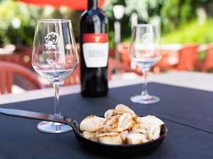 サン・テティエンヌ・ド・バイゴリにあるHôtel Juantorenaのワイングラス2杯、テーブルの上に盛り付けられた料理