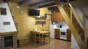eine Küche mit einem Tisch und eine Küche mit einer Treppe in der Unterkunft Robinzonski smještaj Green Peak in Tuhelj