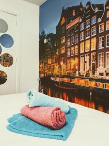 una toalla en una cama con una pintura de una ciudad en H 58 en Ámsterdam