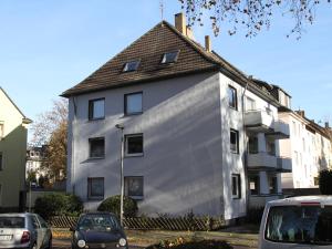a white house with cars parked in front of it at Apartmenthaus in der Arnoldstraße in Bochum +8 photos