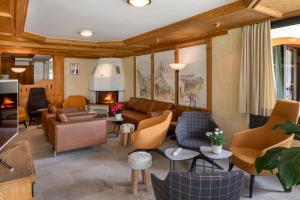 a living room with couches and chairs and a fireplace at Hotel Matterhornblick in Zermatt