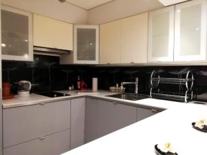 a kitchen with white cabinets and a sink at Studio in Krynica Zdrój