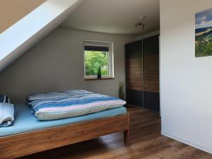 a bedroom with a bed sitting under the stairs at Naturapartments Birkenreuth in Birkenreuth