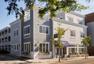 グリーンポートにあるThe Harbor Front Innの白と灰色の外観のアパートメントです。