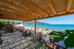 a wooden deck with tables and chairs on the beach at Almyra Seaside Suites in Platis Gialos