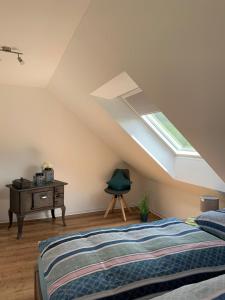 a bedroom with a bed and a desk and a skylight at Naturapartments Birkenreuth in Birkenreuth