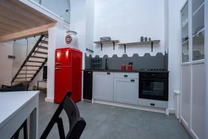 uma cozinha com um frigorífico vermelho e um fogão em Ursino tiny house em Catânia