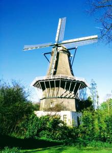 un viejo molino de viento sentado en la cima de un campo en H 58 en Ámsterdam