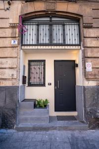uma porta preta no lado de um edifício em Ursino tiny house em Catânia