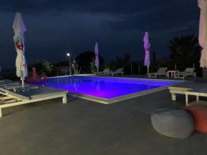 a swimming pool lit up in purple at night at Dela in Hvar