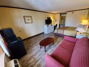 um quarto de hotel com um sofá e uma cama em Days Inn by Wyndham Monett em Monett