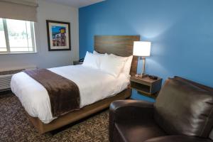 a bedroom with a bed and a chair and a couch at My Place Hotel-Huntersville, NC in Huntersville