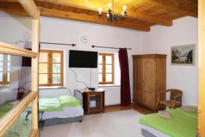 1 dormitorio con 2 camas y TV en la pared en Tanya Üdülőház, en Garáb