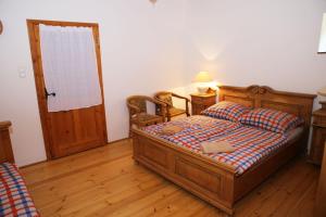 1 dormitorio con cama de madera y puerta en Tanya Üdülőház, en Garáb