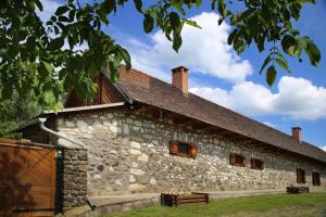 un antiguo edificio de piedra con ventanas y techo en Tanya Üdülőház, en Garáb