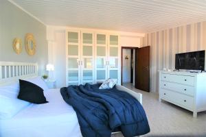 a bedroom with a bed with a blue blanket on it at Capo d'Orlando Apartments - Ottanio in Capo dʼOrlando