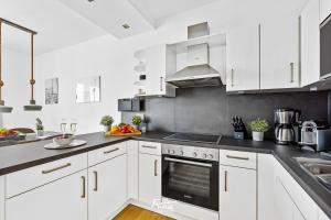 a kitchen with white cabinets and a stove top oven at Portus in Olpenitz