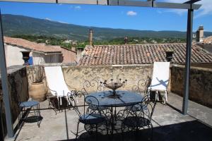 a patio with a table and chairs on a balcony at La carpe diem in Bédoin