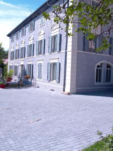 um grande edifício com uma entrada de tijolos em frente em A deux pas du Rheby em Villebois