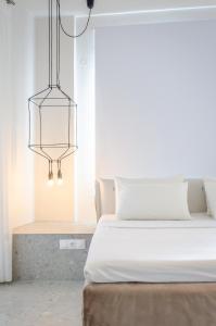 a bedroom with a bed and a chandelier at Egeo in Limenas
