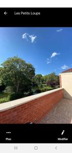 a picture of a brick wall and a blue sky at Le Jardin Minelle in Arras