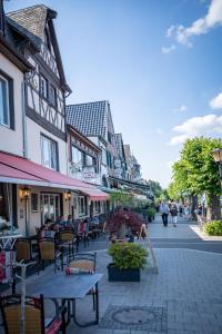 a street with tables and chairs and people walking down the street at Pension Herheinspaziert in Bad Breisig