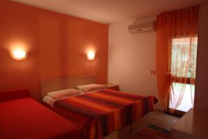 um pequeno quarto com uma cama e uma janela em L'Arcobaleno em Santa Maria la Palma