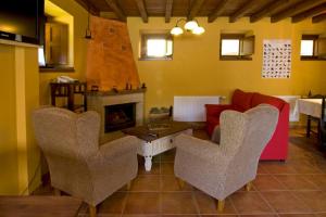 sala de estar con sillas, sofá y chimenea en La Llosa de Repelao, en Covadonga