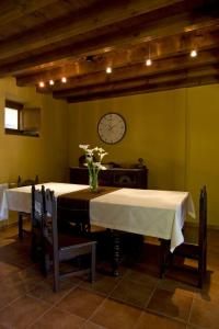 uma sala de jantar com duas mesas e um relógio na parede em La Llosa de Repelao em Covadonga