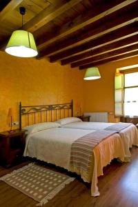 um quarto com uma cama grande e duas luzes em La Llosa de Repelao em Covadonga