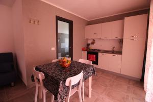 a kitchen with a table with a bowl of fruit on it at Chiaro di Luna in Santa Domenica +17 photos