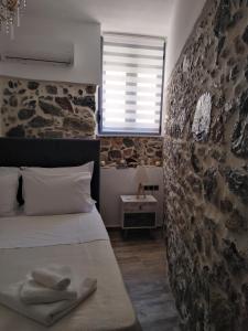 a bedroom with a stone wall and a bed at Villa Olga in Agalianós