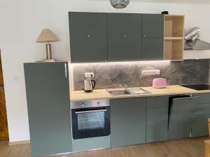 uma cozinha com armários cinzentos e uma bancada em Modern apartment in Kutna Hora em Kutná Hora