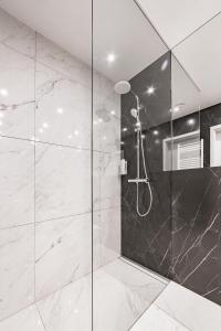 ヴロツワフにあるOdra View Apartments IIの黒と白の大理石のバスルーム(シャワー付)