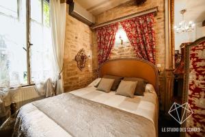 Chambre d'hôtes Le Petit Tertre في ديجون: غرفة نوم بسرير ونافذة كبيرة