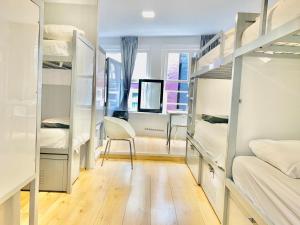 a dorm room with a desk and bunk beds at The White Tulip Hostel in Amsterdam