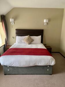 een slaapkamer met een groot bed en een rode deken bij The Draper Rooms in Dublin